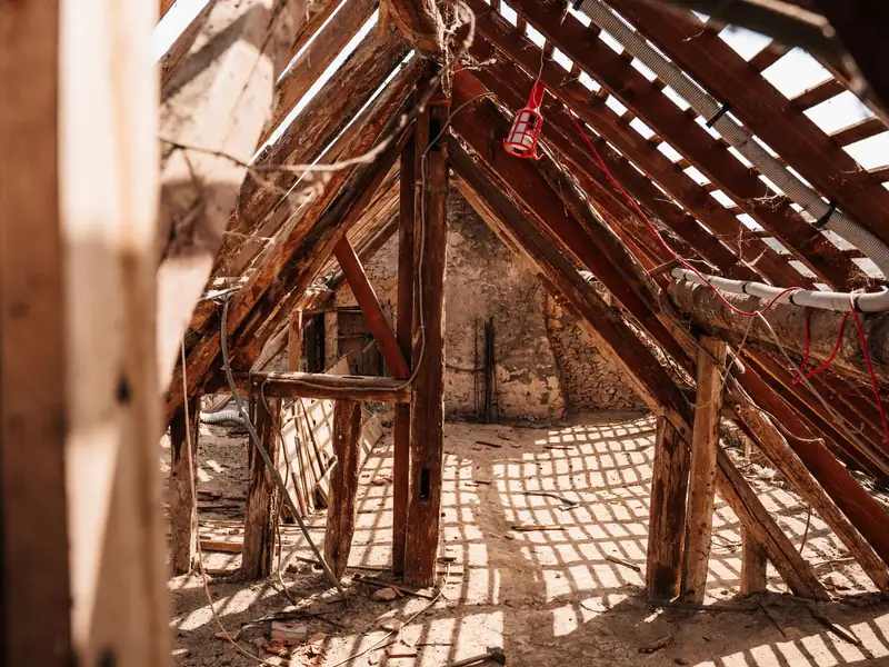 Chevrons et poutres de bois apparents dans des combles en travaux